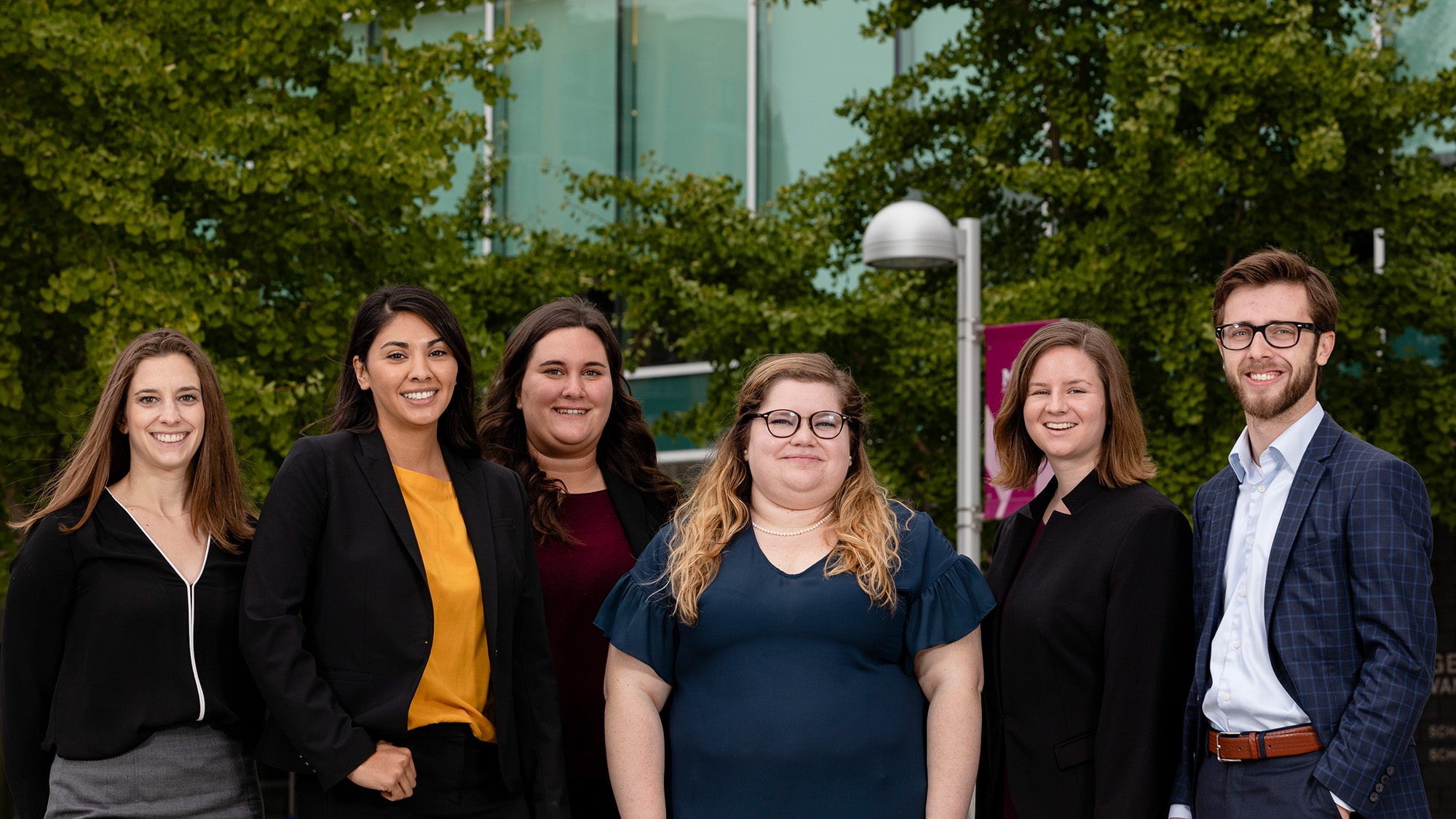 Six students in the Immigration Litigation Clinic pose for a photo outside of the law school.