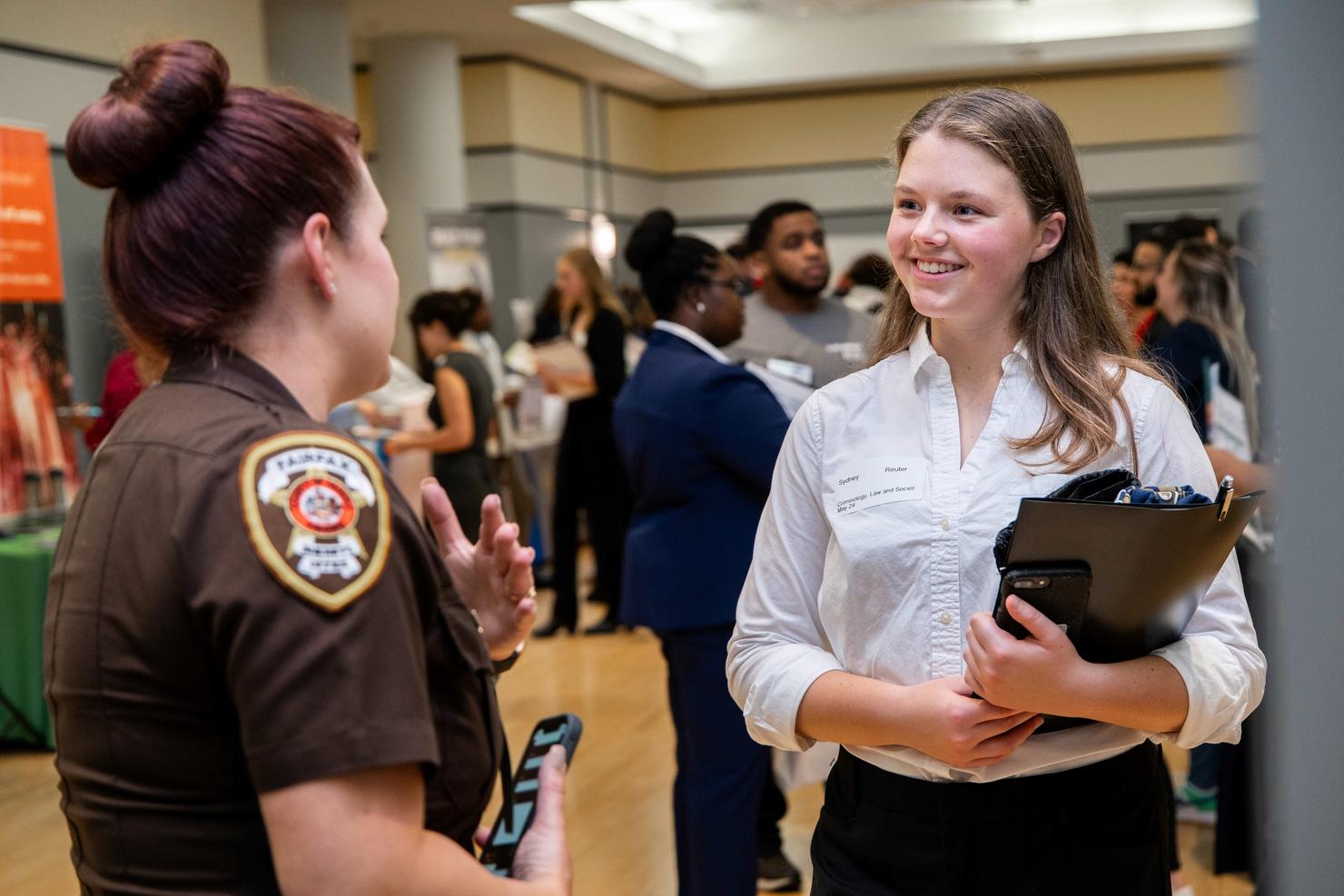 A student speaks to a law enforcement recruiter at the Career Fair