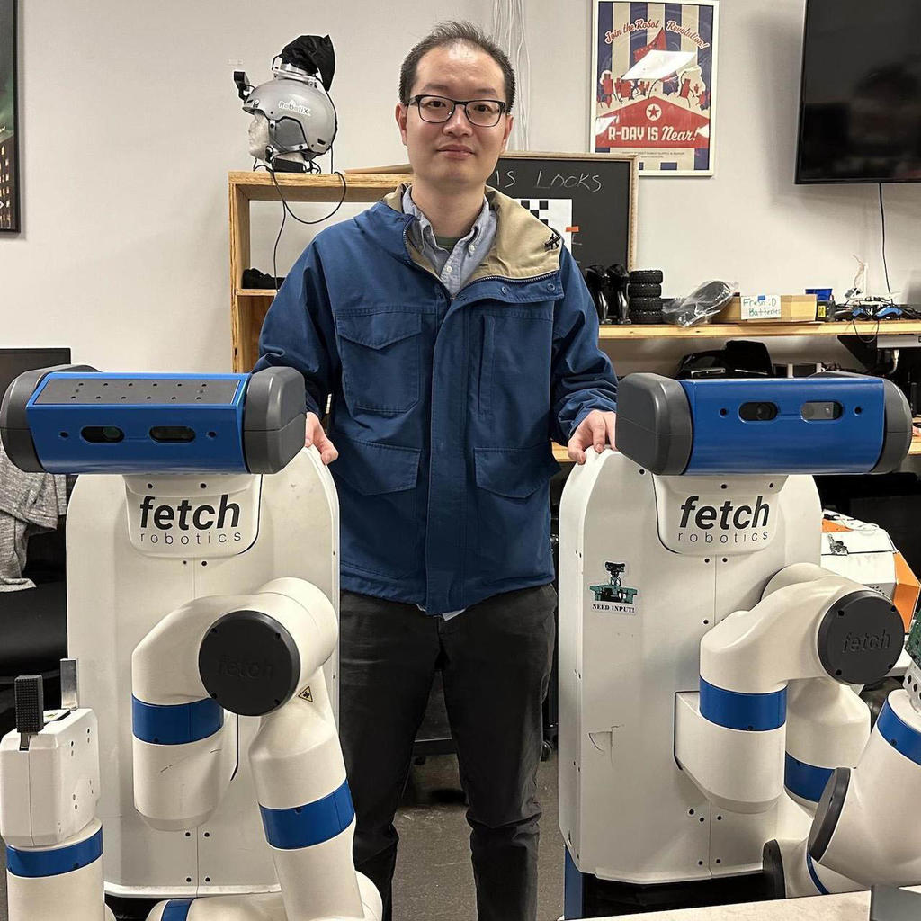 Assistant Professor Xuan Wang and two robots